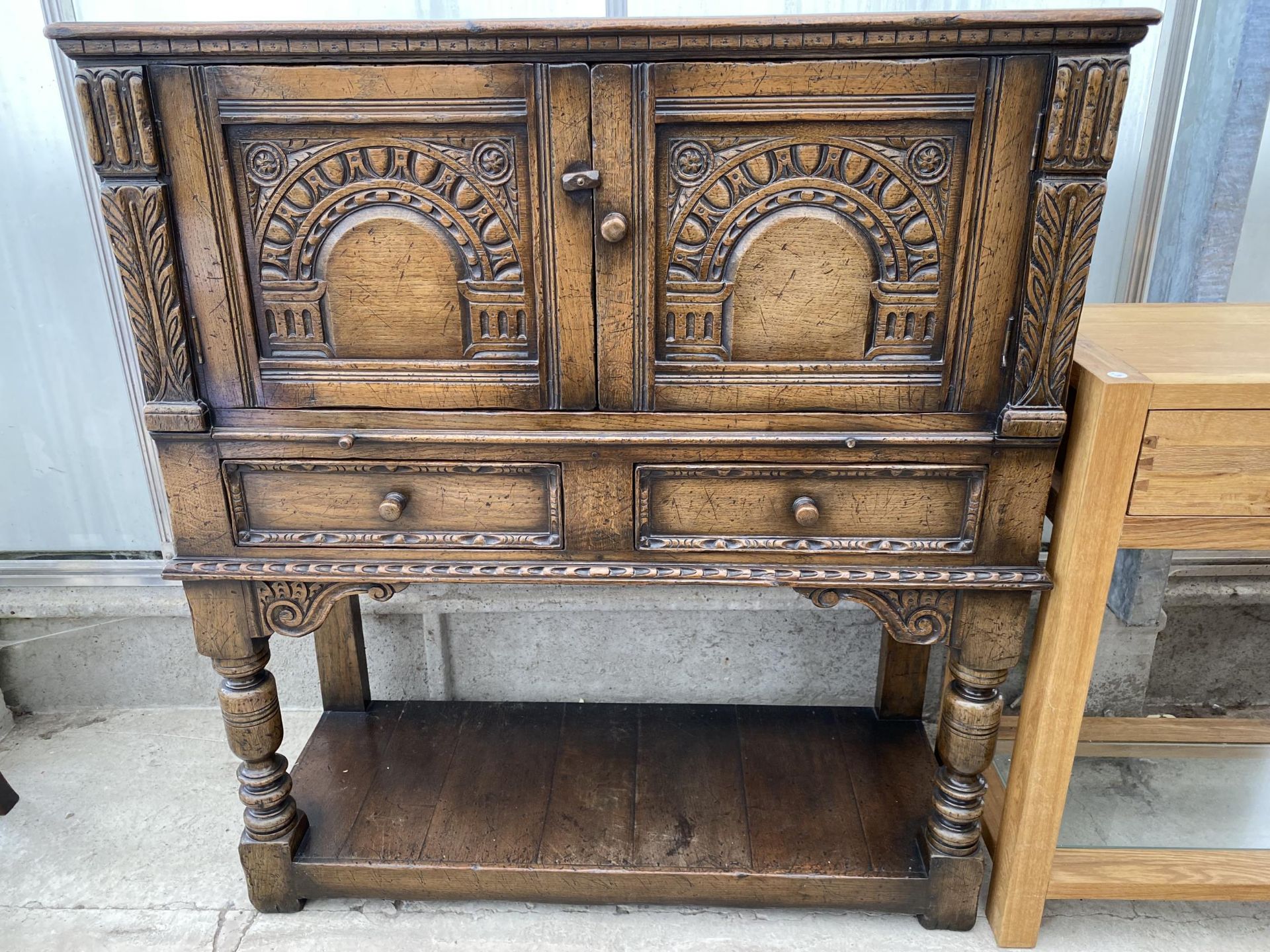 AN OAK JACOBEAN STYLE COCKTAIL CABINET WITH PANELLED DOOR, PULL OUT SLIDE, TWO DRAWERS AND A POT - Image 2 of 7