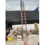 A VINTAGE WOODEN TWO SECTION 24 RUNG EXTENDING LADDER