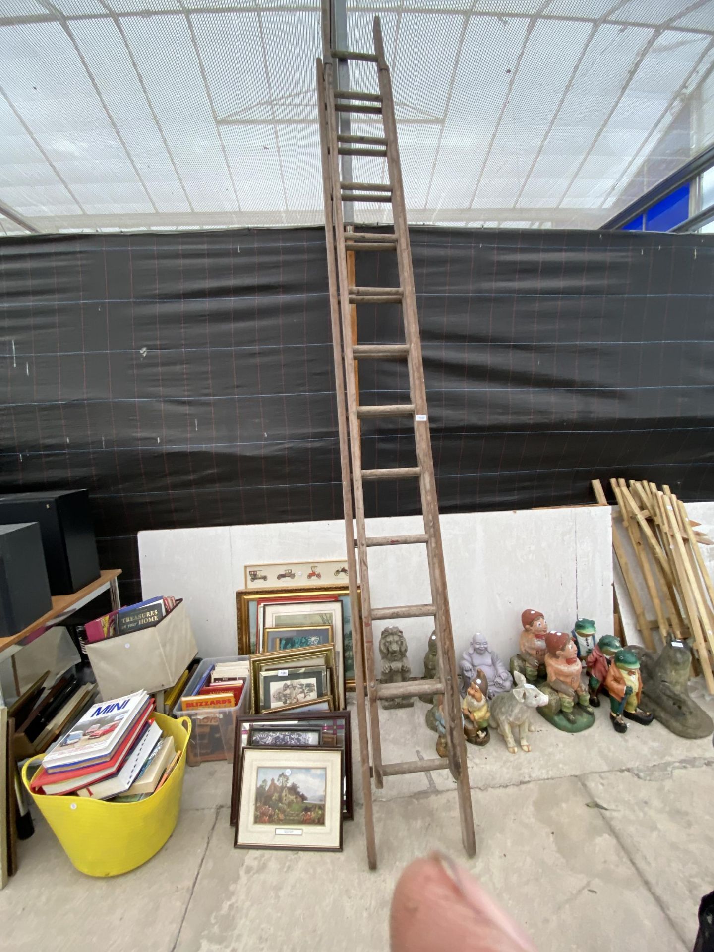 A VINTAGE WOODEN TWO SECTION 24 RUNG EXTENDING LADDER