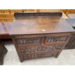 AN OAK HEAVILY CARVED JACOBEAN CHEST OF TWO SHORT AND TWO LONG DRAWERS 34" WIDE