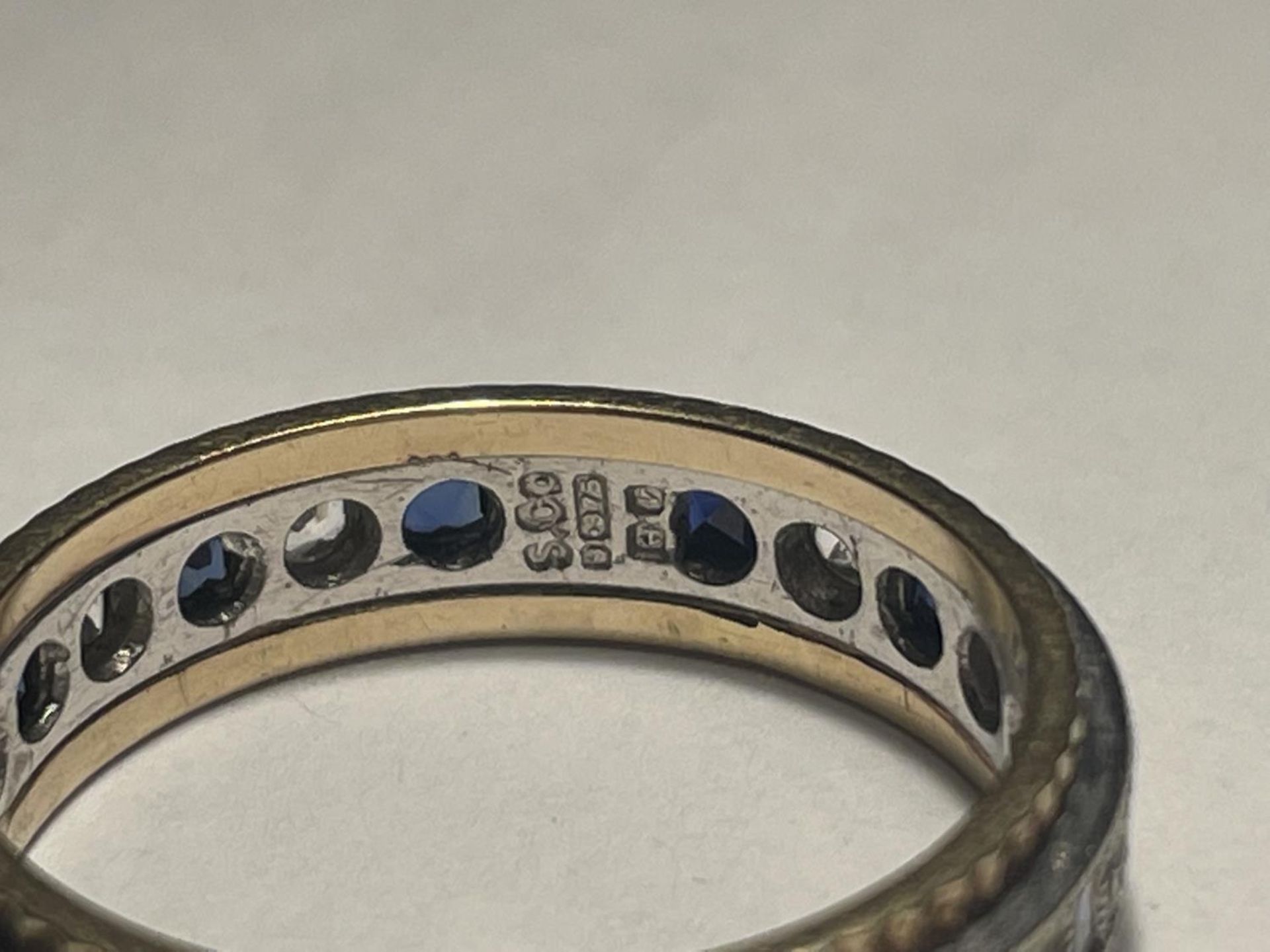 A 9 CARAT GOLD RING WITH A BAND OF SAPPHIRES AND CUBIC ZIRCONIA STONES - Image 3 of 3