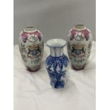 A PAIR OF VINTAGE VASES WITH EMBOSSED FLORAL DESIGN AND A CREST OF ARMS HEIGHT 22CM PLUS A DELFT