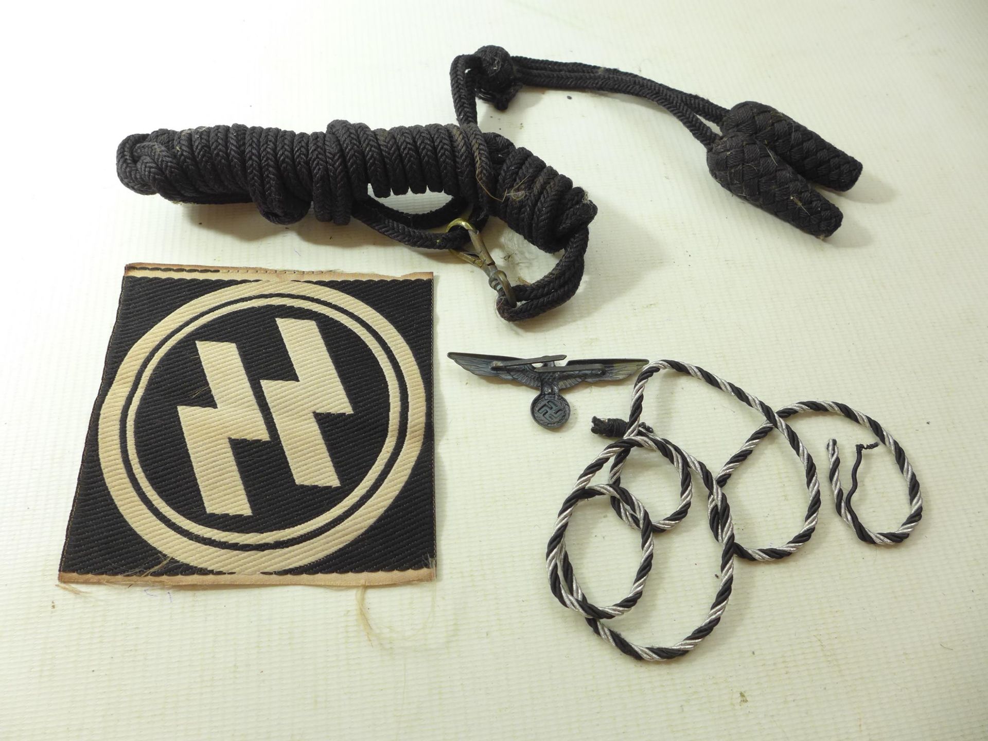 A NAZI GERMANY SS CLOTH BADGE, TWO LOTS OF BRAID AND AN EAGLE & SWASTIKA BADGE - Image 2 of 2
