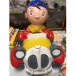 A HARD PLASTIC NODDY IN HIS CAR MODEL CHARITY MONEY BOX MISSING HIS HAT AND THE BASE - 32 CM WIDE