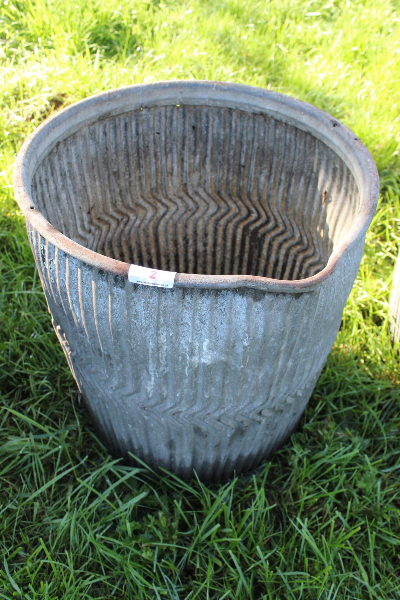 A DOLLY TUB WITH A TIPPING LIP A/F (SOME HOLES IN THE BOTTOM + VAT