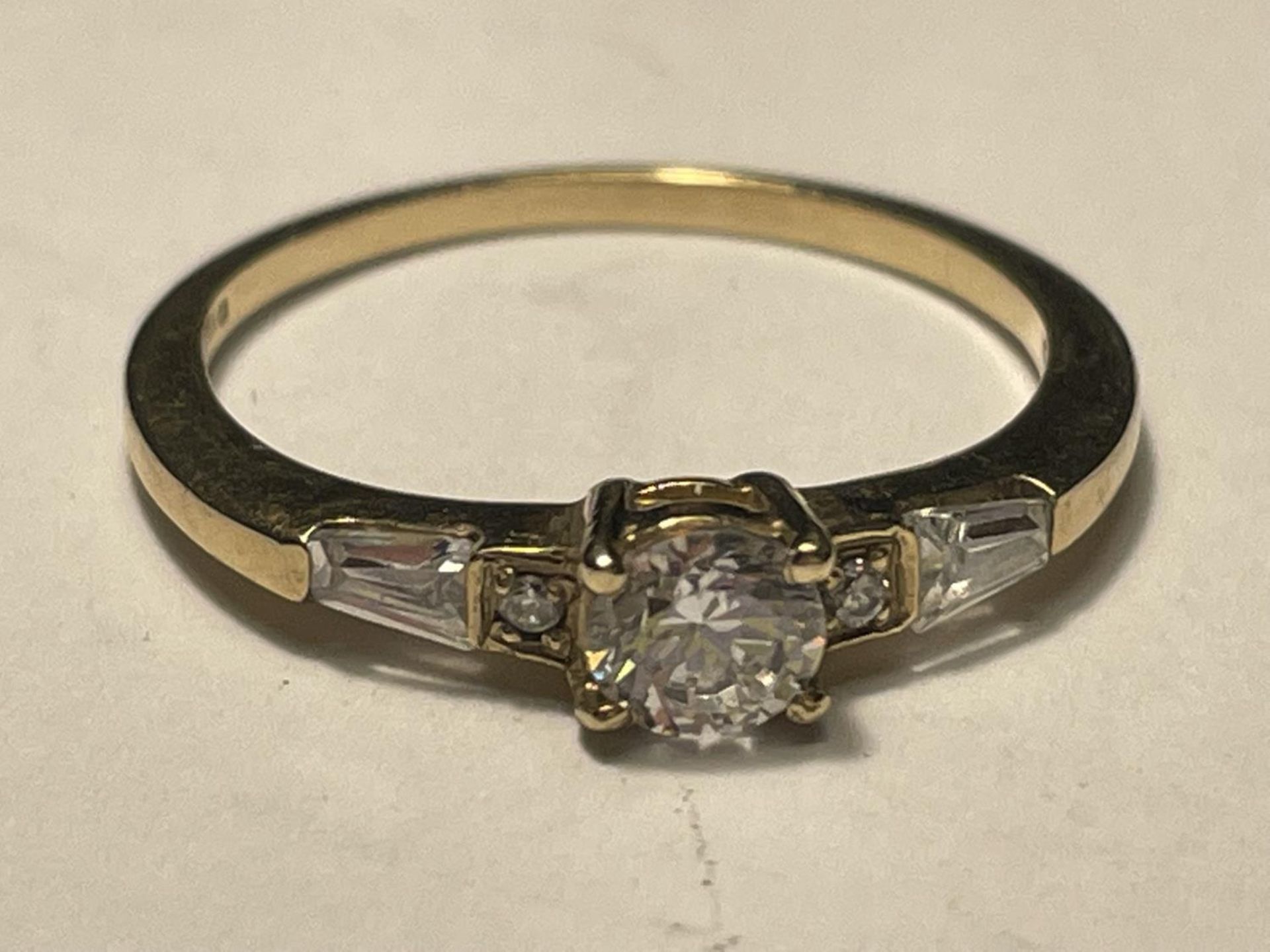 A 9 CARAT GOLD RING WITH CUBIC ZIRCONIAS IN A DECO STYLE SETTING SIZE O