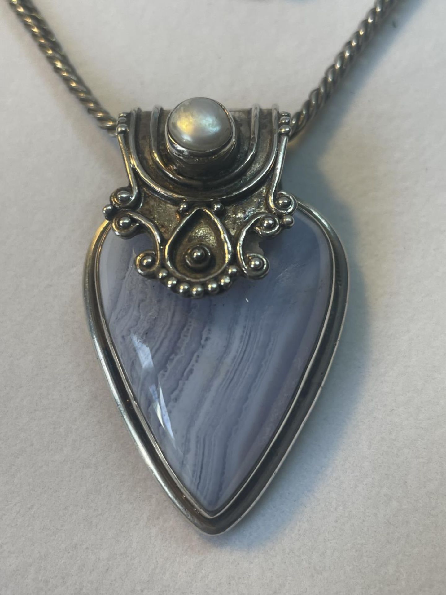 A MARKED SILVER NECKLACE WITH AN ORNATE FRAMED BLUE STONE PENDANT - Image 2 of 4