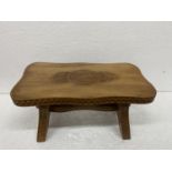 A WOODEN STOOL WITH ENGRAVED DECORATION HEIGHT 17CM, WIDTH 35CM