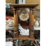 A MAHOGANY CASED WALL CLOCK WITH COLUMN DECORATION TO INCLUDE THE PENDULUM AND KEY