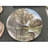 A LARGE CERAMIC WALL PLATE WITH A RIVER SCENE - SIGNED DIAMETER 33CM