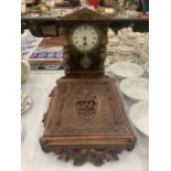 A HEAVILY CARVED OAK KEY BOX WITH ELABORATE DECORATION AND A SMALL MAHOGANY CASED WALL CLOCK WITH