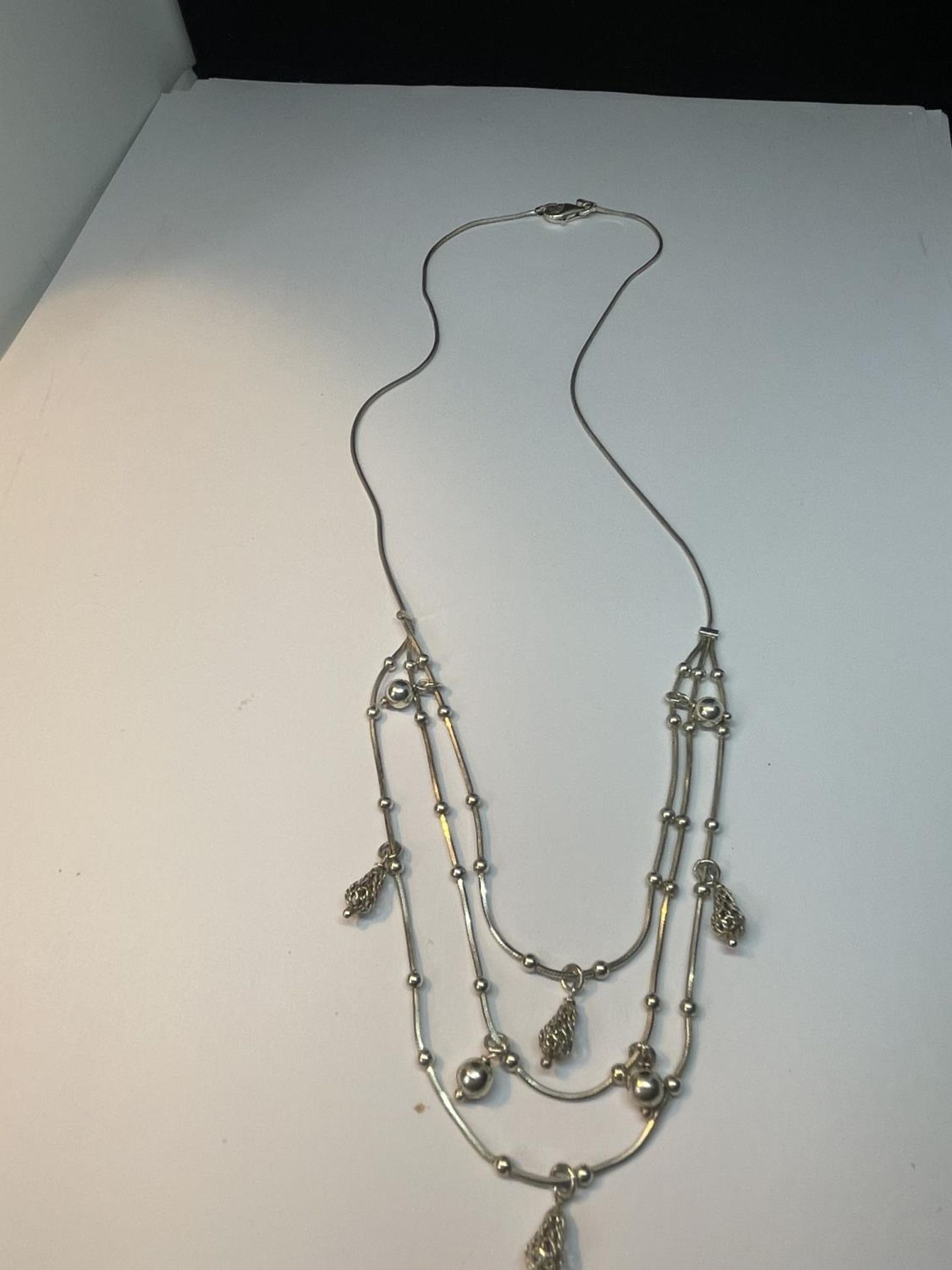 A MARKED SILVER NECKLACE WITH A THREE STRAND DESIGN IN A PRESENTATION BOX