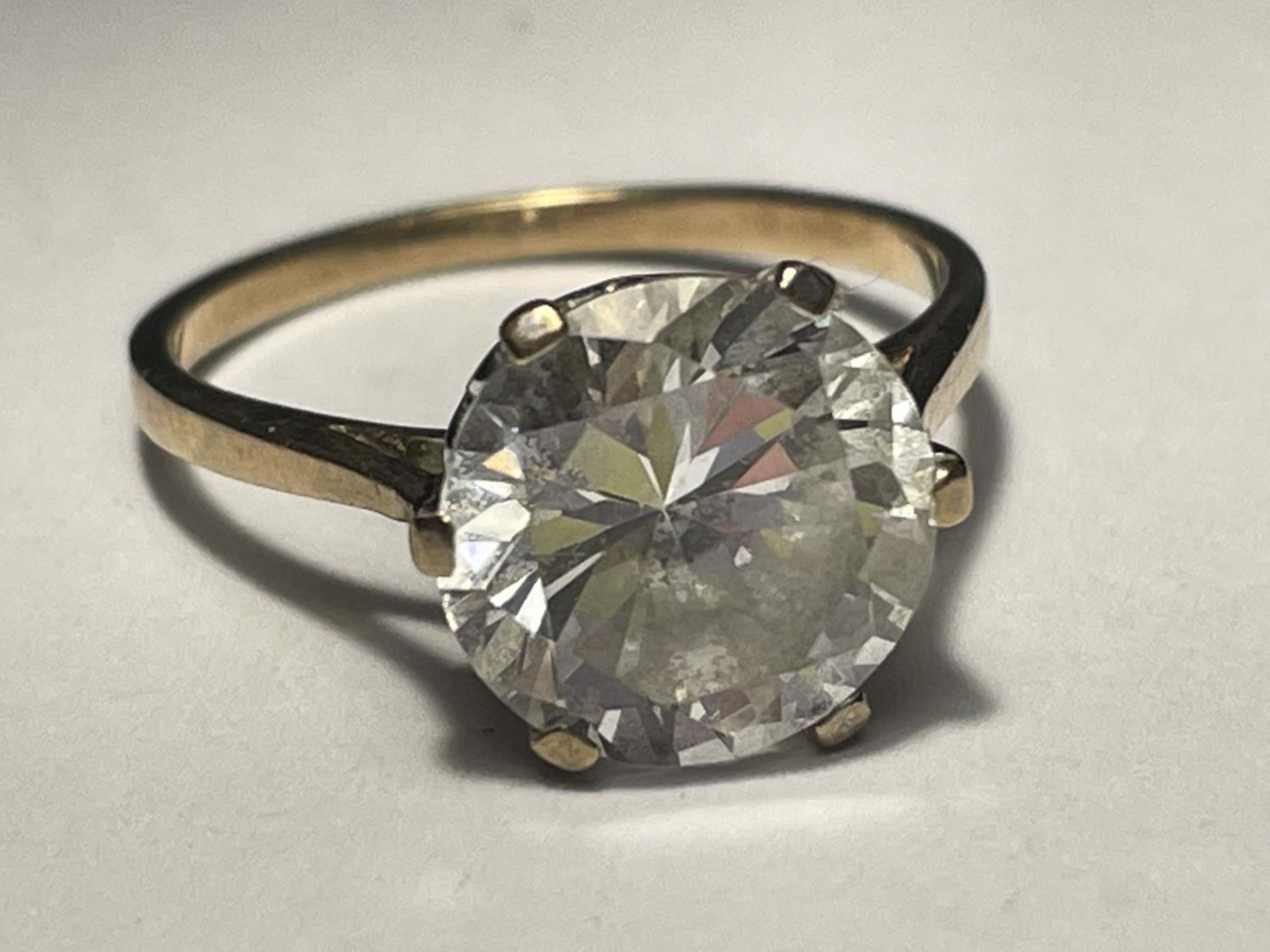 A 9 CARAT GOLD CLEAR STONE SOLITAIRE RING SIZE M/N