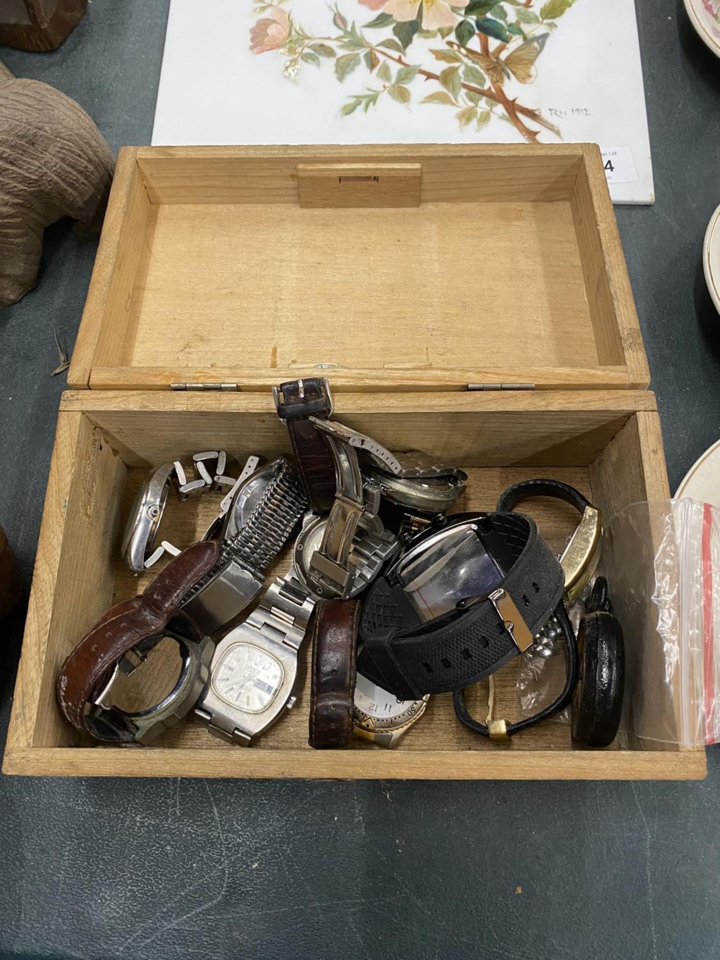 A VINTAGE WOODEN BOX CONTAINING TEN VINTAGE WATCHES TO INCLUDE TIMBERLAND, ACCURIST, ETC