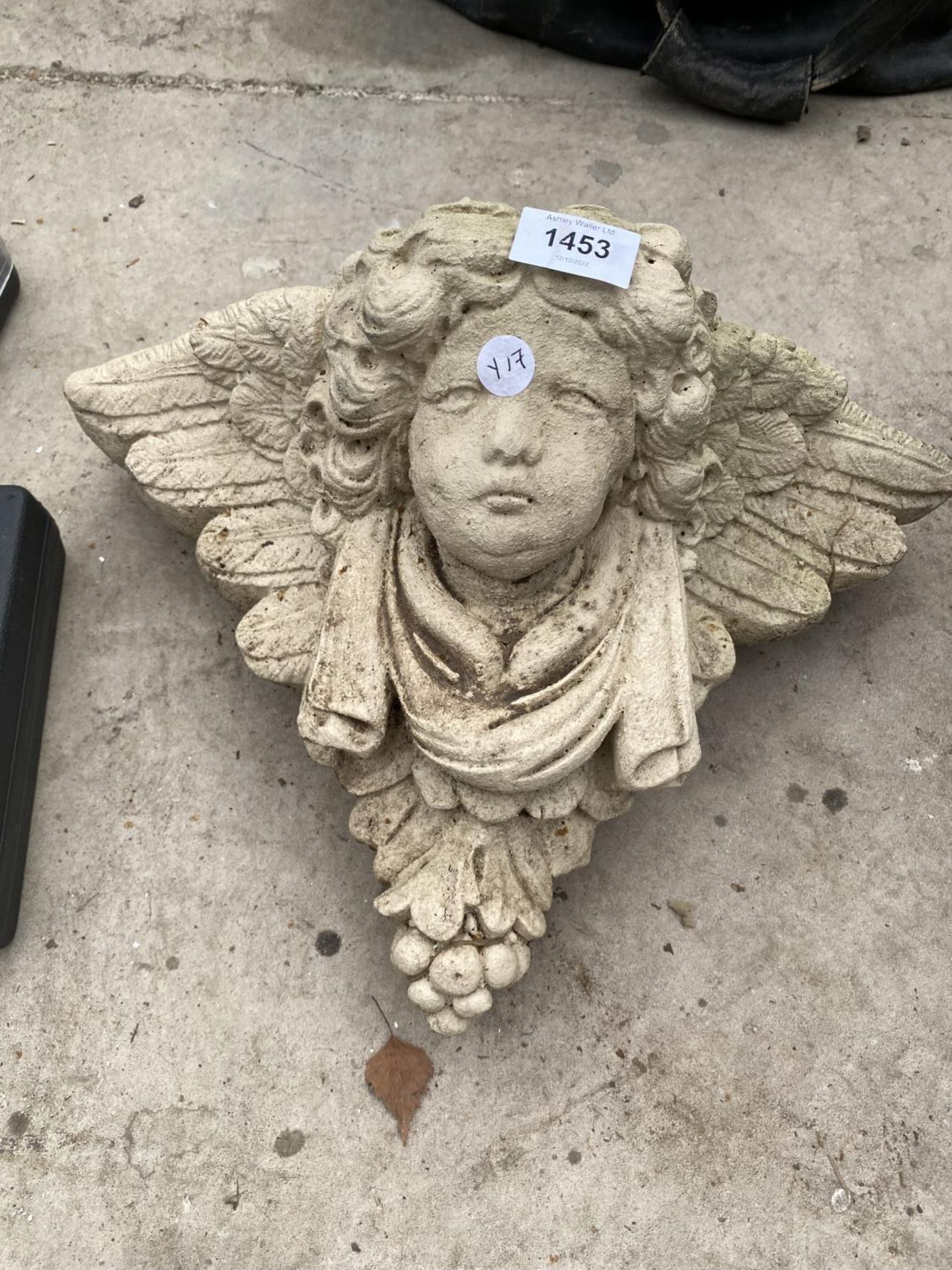 A RECONSTITUTED STONE WALL HANGING CHERUB POCKET PLANTER