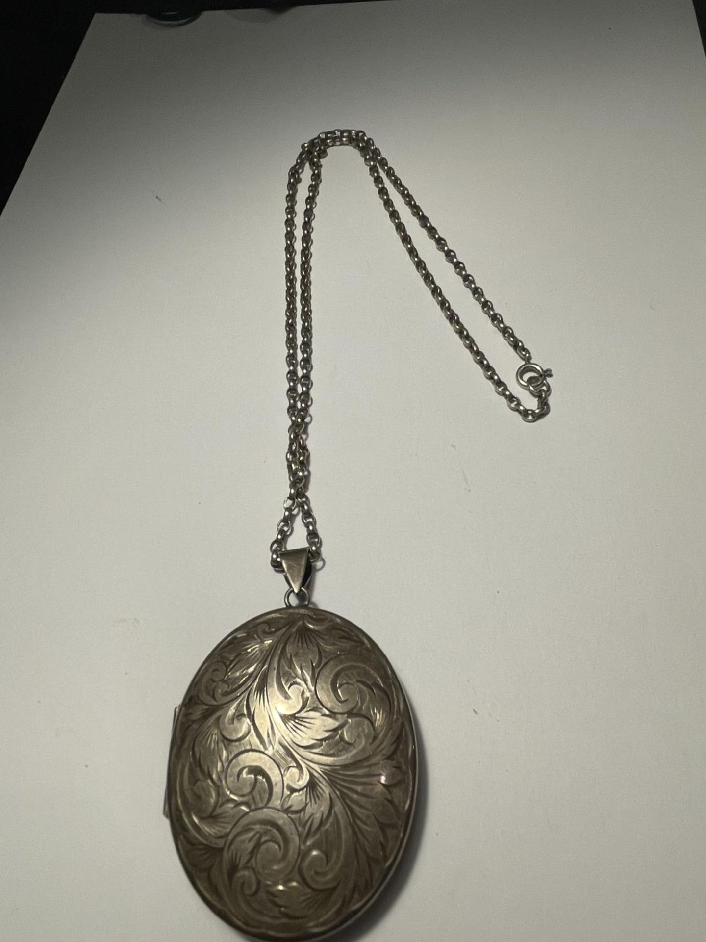 A LARGE HALLMARKED BIRMINGHAM SILVER LOCKET ON A MARKED SILVER CHAIN