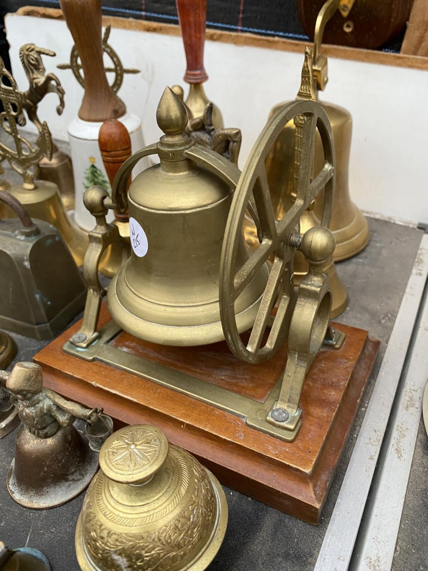 A LARGE QUANTITY OF BRASS HAND BELLS TO INCLUDE A BRASS SHIPS BELL WITH WOODEN PLINTH AND PULLEY - Image 3 of 5