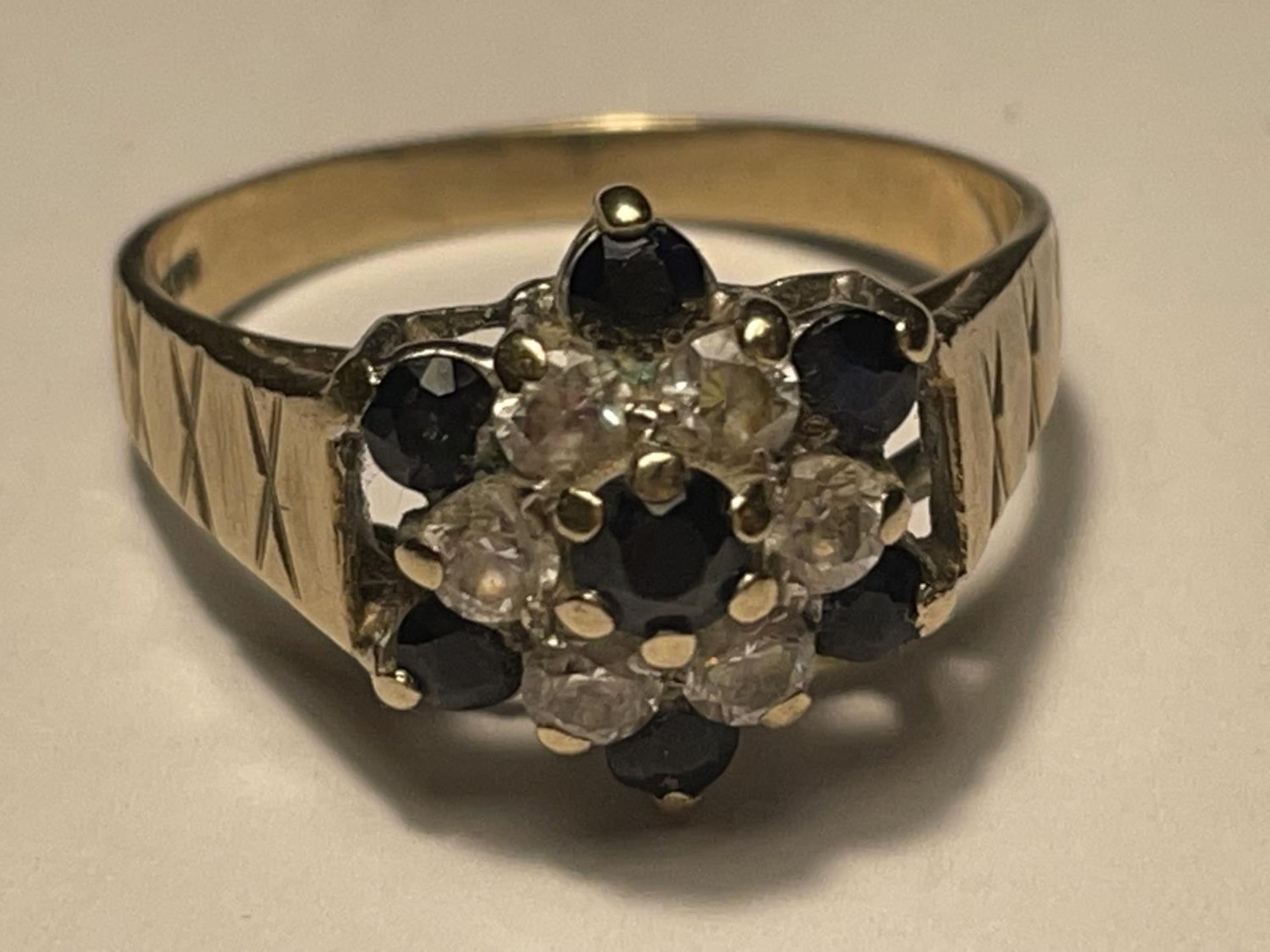 A 9 CARAT GOLD RING WITH SAPPHIRES AND CUBIC ZIRCONIAS IN A FLOWER DESIGN SIZE R