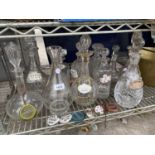 A LARGE QUANTITY OF GLASS DECANTORS WITH VARIOUS CERAMIC DECANTOR LABELS