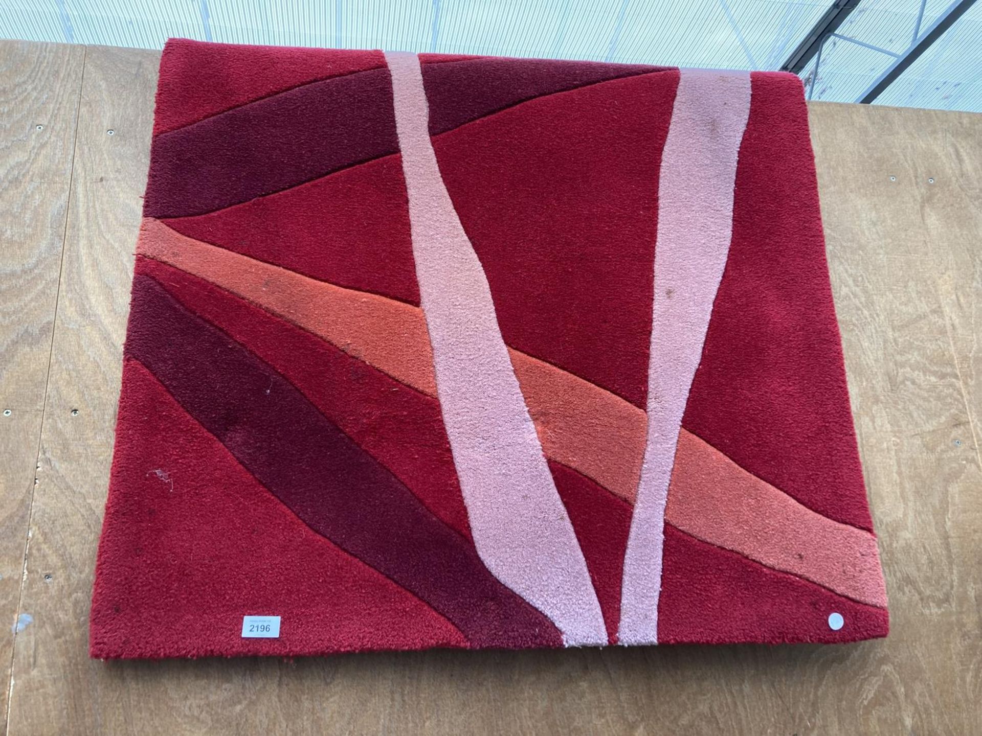 A MODERN RED PATTERNED RUG