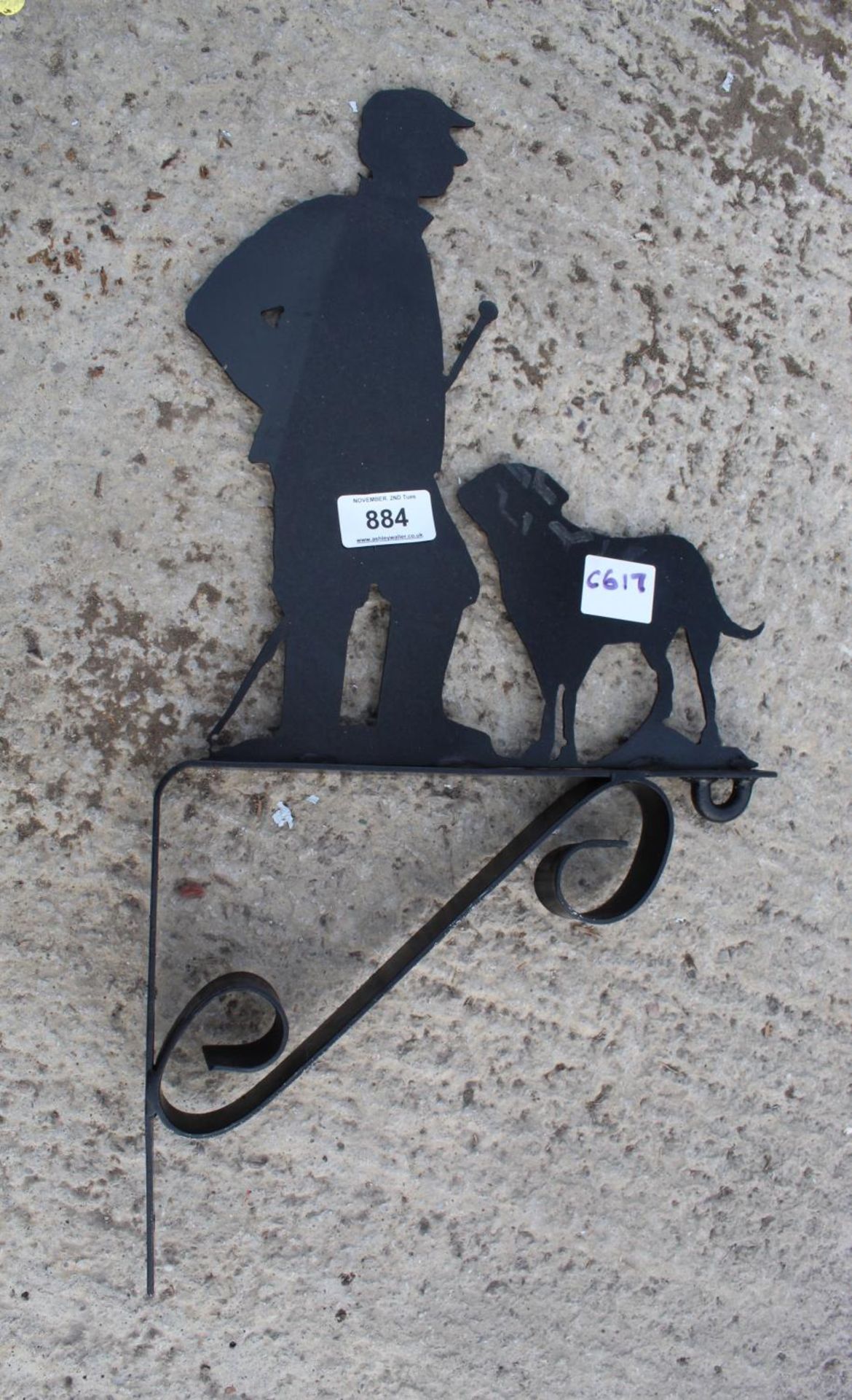 A METAL WALL HANGING BRACKET DEPICTING A MAN AND HIS DOG NO VAT