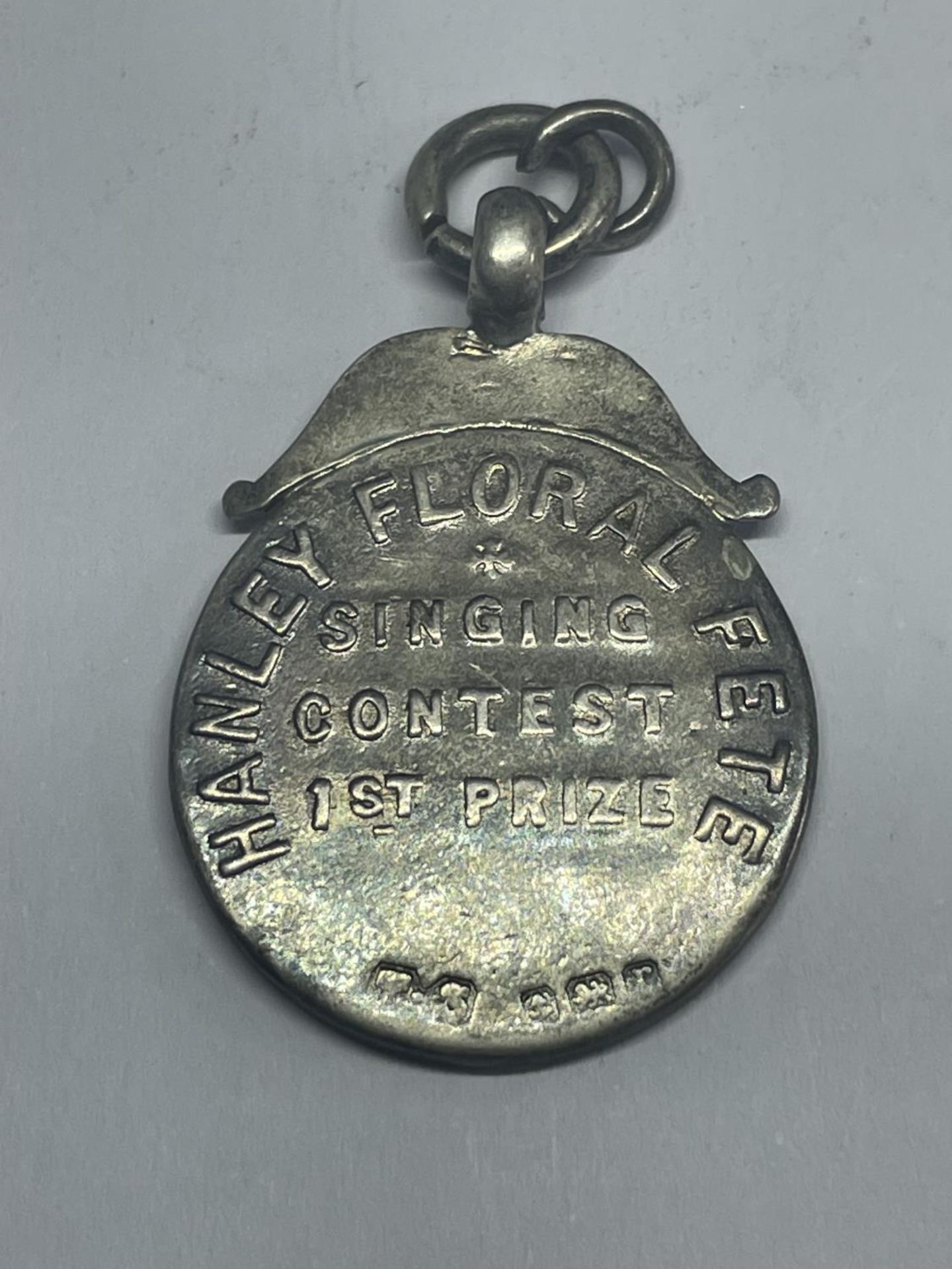A HALLMARKED BIRMINGHAM SILVER HANLEY FLORAL FETE SINGING CONTEST FIRST PRIZE MEDAL