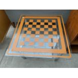 A RETRO GLASS TOP GAMES/LAMP TABLE ON POLISHED CHROME FRAME, 25" SQUARE