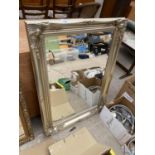 A DECORATIVE SILVER COLOURED FRAMED WALL MIRROR