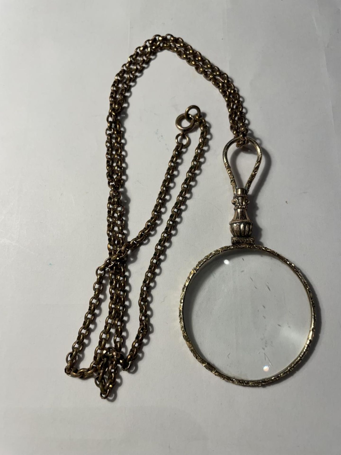 A YELLOW METAL CHAIN WITH A DECORATIVE MAGNIFYING GLASS PENDANT IN A PRESENTATION BOX - Image 4 of 4