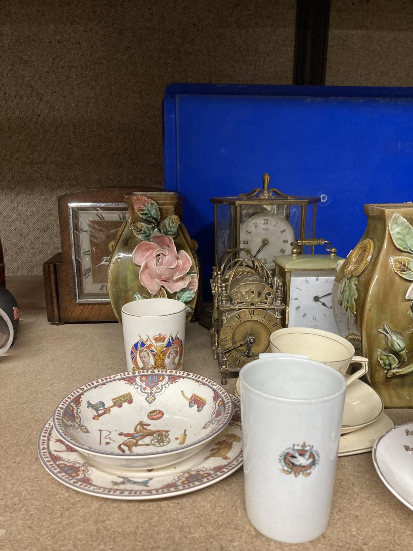 A MIXED LOT TO INCLUDE BRASS LANTERN CLOCKS, VINTAGE MANTLE CLOCKS, VASES, COMMEMORATIVE CUPS, ETC