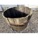 AN OAK HALF BARREL PLANTER WITH METAL BANDING (H:63CM D:89CM)