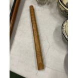 A WOODEN FLUTE WITH CHIP. CARVED DECORATION LENGTH 32CM