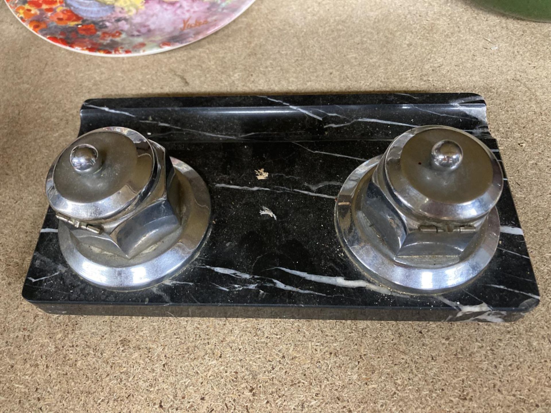 A SET OF TWO CHROME INKWELLS ON A MARBLE STYLE BASE