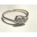 A 9 CARAT GOLD AND PLATINUM RING WITH THREE IN LINE DIAMONDS ON A TWIST SETTING SIZE O/P