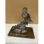 A PEWTER FIGURE OF A FALCON IN A WOODEN BASE