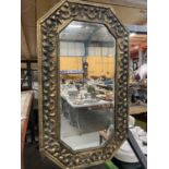 A VINTAGE BRASS OCTAGONAL MIRROR WITH FLORAL AND SHELL EMBOSSED DECORATION 73CM X 44CM