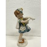 A GOLDSHIEIDER FIGURE OF GIRL PUTTING ON GLOVES HEIGHT 23CMS