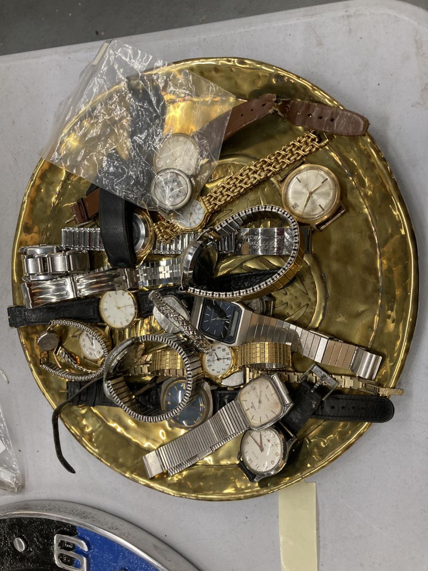 A BRASS TRAY CONTAINING A QUANTITY OF WRISTWATCHES TO INCLUDE TIMEX, MONVAL, LORUS, ETC