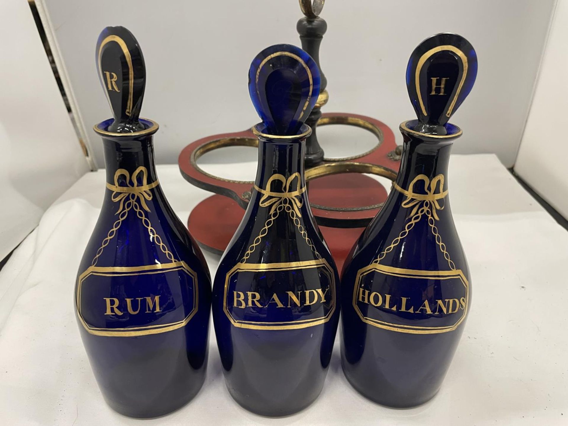 A SET OF THREE GEORGE III GILDED BRISTOL BLUE GLASS DECANTERS IN BRASS AND LAQUERED FRAME - Image 3 of 4