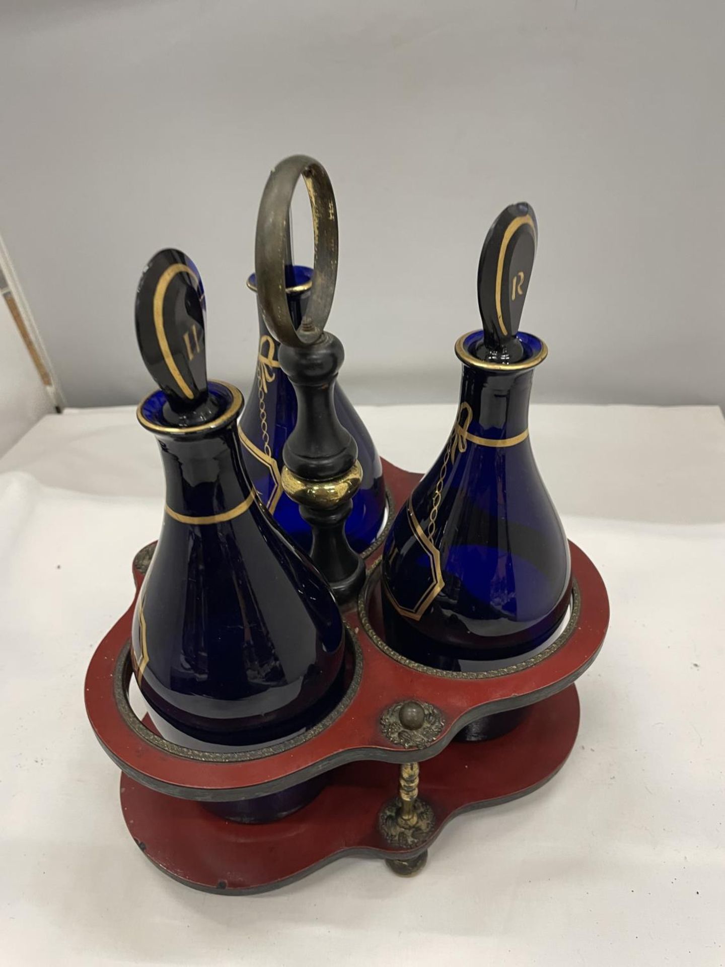 A SET OF THREE GEORGE III GILDED BRISTOL BLUE GLASS DECANTERS IN BRASS AND LAQUERED FRAME - Image 2 of 4