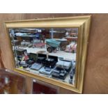 A LARGE GILT FRAMED WALL MIRROR (H:72CM W:102CM)