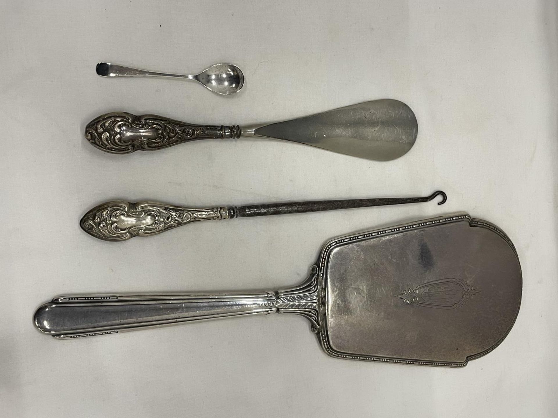 FOUR SILVER ITEMS TO INCLUDE A BACKED MIRROR, A MUSTARD SPOON AND TWO HANDLES ITEMS BUTTON HOOK