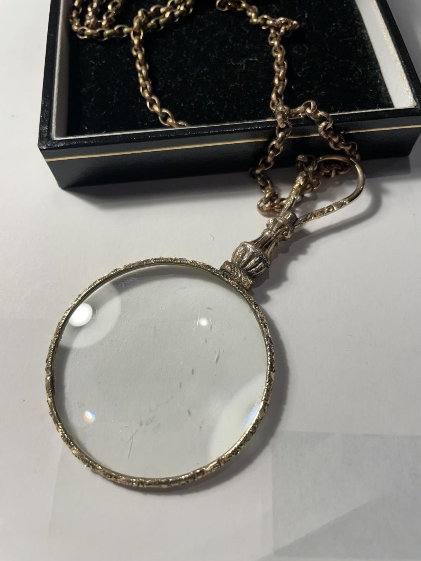 A YELLOW METAL CHAIN WITH A DECORATIVE MAGNIFYING GLASS PENDANT IN A PRESENTATION BOX - Image 3 of 4