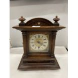 AN ANTIQUE MANTLE CLOCK WITH ROMAN NUMERAL FACE