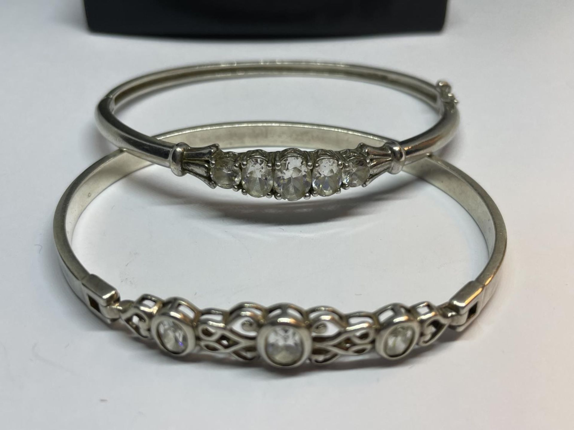 TWO SILVER BANGLES WITH CLEAR STONES IN A PRESENTATION BOX