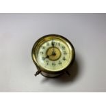 A SMALL VINTAGE BRASS CAR CLOCK WITH ENAMEL DIAL