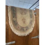 A CREAM PATTERNED OVAL FRINGED RUG