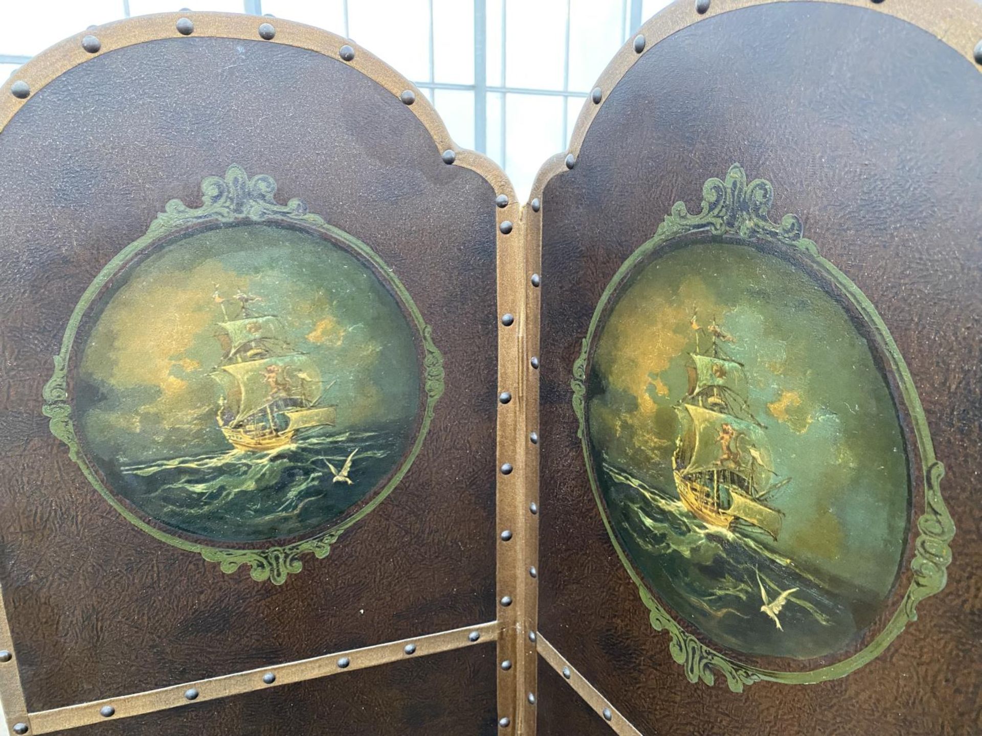 AN EDWARDIAN FOUR DIVISION STUDDED LEATHERETTE SCREEN WITH ARCHED TOPS HAVING PAINTED MASTED SHIP - Image 3 of 4