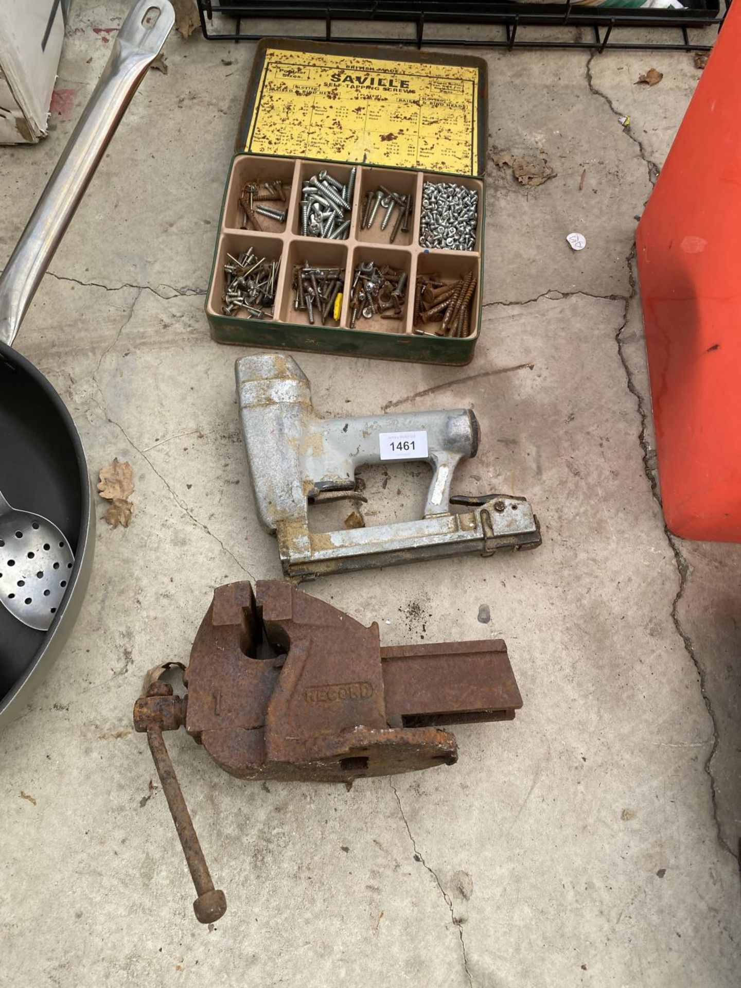 A SMALL RECORD BENCH VICE, A STAPLE GUN AND A TIN OF HARDWARE