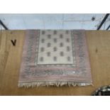 A SMALL PINK PATTERNED FRINGED RUG